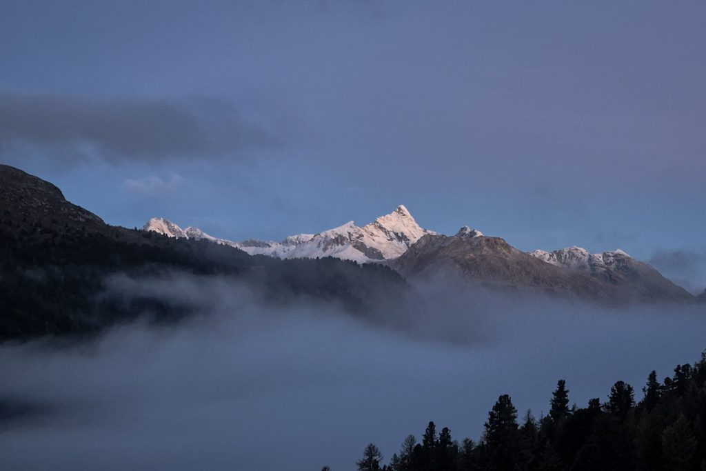 Il Piz Ot innevato nella penombra che precede l'alba, con il cielo che inizia a schiarire