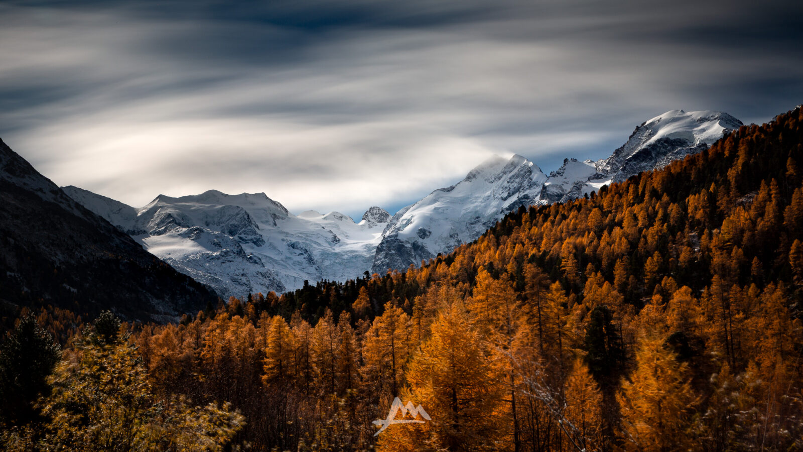 Prima neve sulle cime dell’Engadina sopra boschi dai colori autunnali